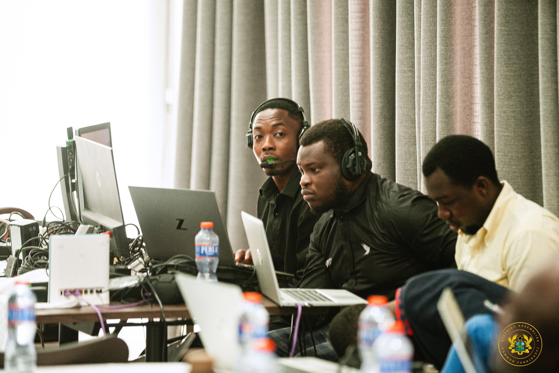 Three broadcast crew members coordinating a live production